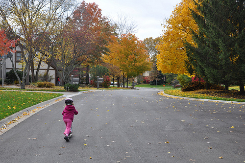 Alana scooters past the colors of autumn